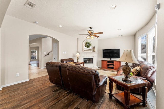 406 Oak Stream Dr, Conroe, TX 77304 - living area with ceiling fan, wood finished floors, arched walkways, recessed lighting, and a fireplace with raised hearth