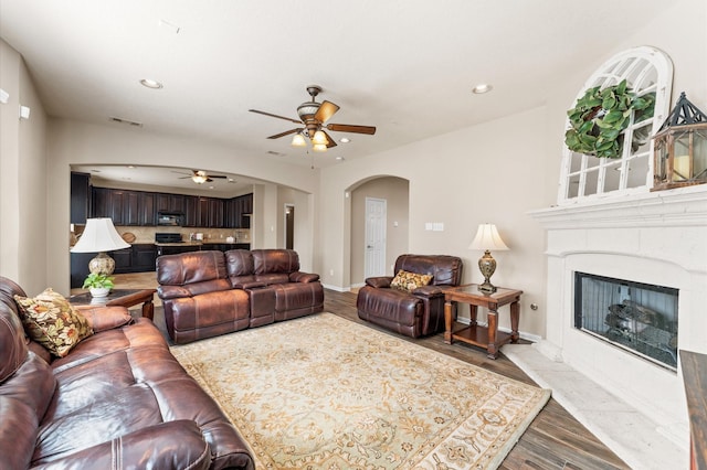 406 Oak Stream Dr, Conroe, TX 77304 - living room with wood finished floors, ceiling fan, arched walkways, recessed lighting, and a premium fireplace