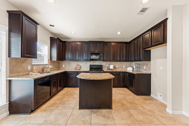 406 Oak Stream Dr, Conroe, TX 77304 - kitchen with black appliances, light stone countertops, dark brown cabinetry, a sink, and recessed lighting