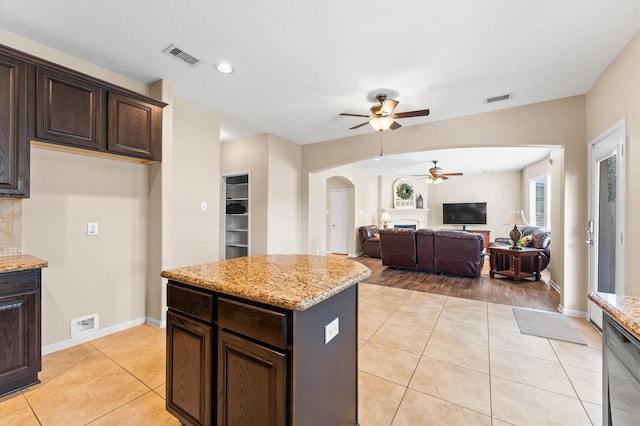 406 Oak Stream Dr, Conroe, TX 77304 - kitchen with ceiling fan, arched walkways, light tile patterned flooring, dark brown cabinets, and recessed lighting
