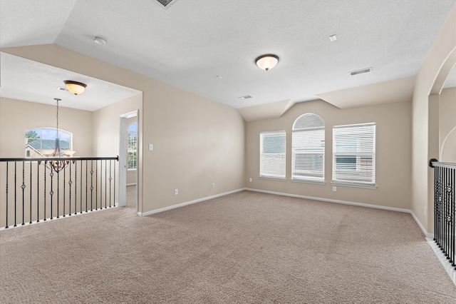 406 Oak Stream Dr, Conroe, TX 77304 - carpeted empty room featuring vaulted ceiling, baseboards, and a textured ceiling