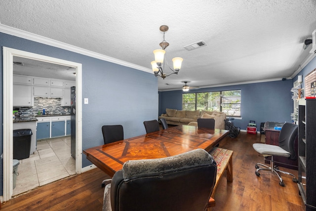 917 Alvin St, Pasadena, TX 77506 - dining area with crown molding, a chandelier, wood finished floors, a textured ceiling, and baseboards