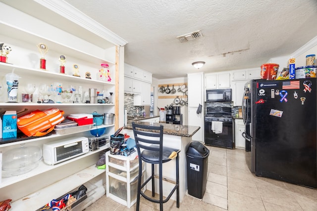 917 Alvin St, Pasadena, TX 77506 - kitchen featuring black appliances, white cabinets, light tile patterned floors, a textured ceiling, and a peninsula