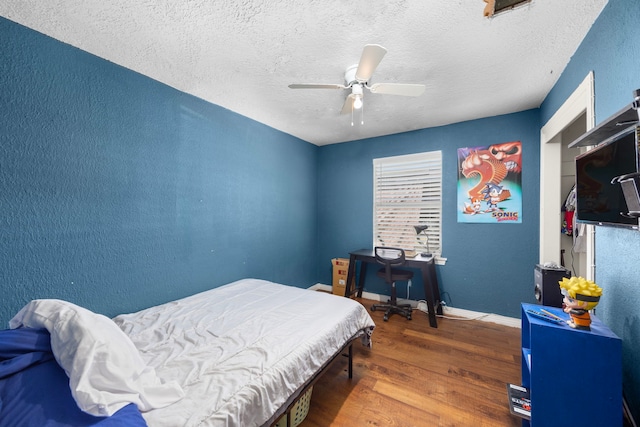 917 Alvin St, Pasadena, TX 77506 - bedroom featuring wood finished floors, a textured ceiling, a textured wall, baseboards, and a ceiling fan