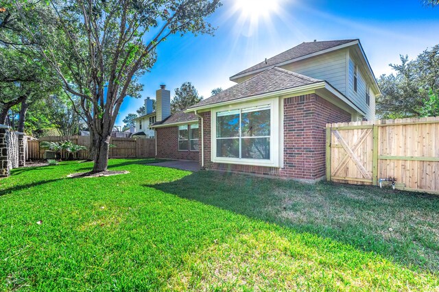 24034 River Place Dr, Katy, TX 77494 - back of house featuring brick siding, a shingled roof, and a gate