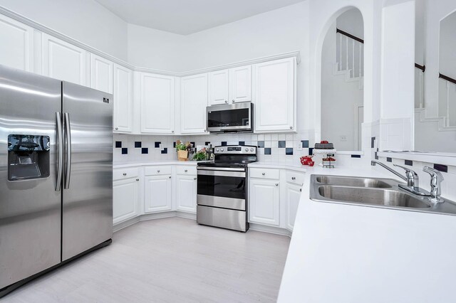 24034 River Place Dr, Katy, TX 77494 - kitchen featuring stainless steel appliances, a sink, decorative backsplash, and white cabinetry