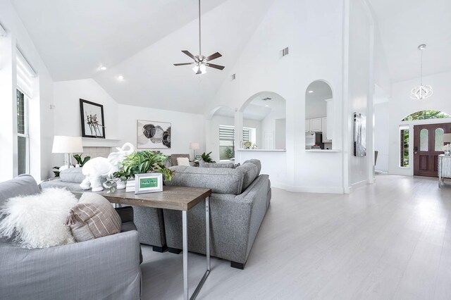 24034 River Place Dr, Katy, TX 77494 - living room with a ceiling fan, light wood-style flooring, arched walkways, high vaulted ceiling, and baseboards