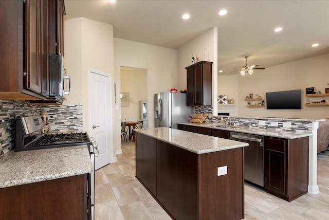 15031 Appian Oak St, Cypress, TX 77429 - kitchen with appliances with stainless steel finishes, a kitchen island, ceiling fan, a peninsula, and dark brown cabinets