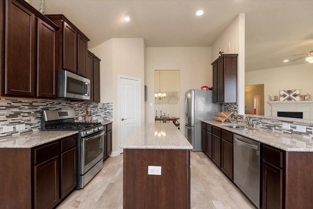 15031 Appian Oak St, Cypress, TX 77429 - kitchen with stainless steel appliances, a sink, tasteful backsplash, dark brown cabinets, and recessed lighting
