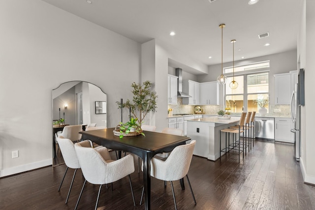 111 E 2nd St, Houston, TX 77007 - dining space featuring dark wood-style flooring, arched walkways, and recessed lighting