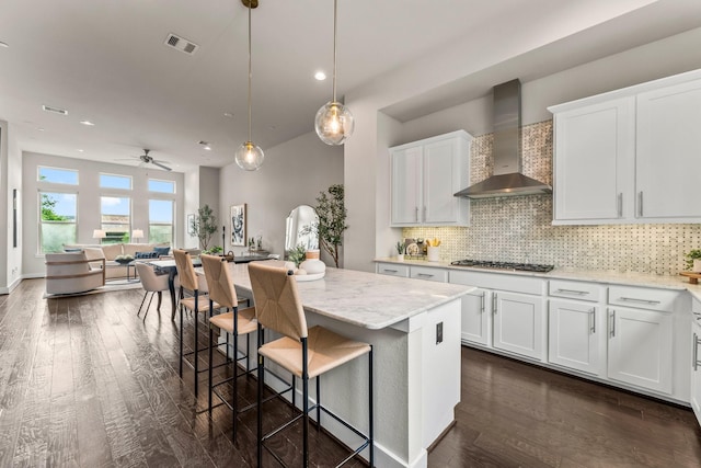 111 E 2nd St, Houston, TX 77007 - kitchen with wall chimney range hood, gas cooktop, white cabinets, dark wood finished floors, and recessed lighting