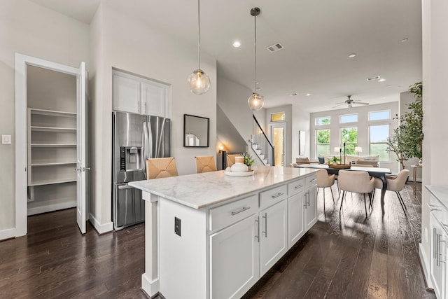 111 E 2nd St, Houston, TX 77007 - kitchen featuring stainless steel refrigerator with ice dispenser, dark wood-style flooring, a kitchen island, white cabinetry, and light stone counters