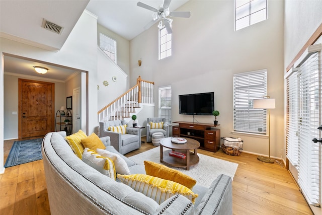 1538 Bevis St, Houston, TX 77008 - living area featuring stairs, light wood finished floors, a towering ceiling, ceiling fan, and plenty of natural light