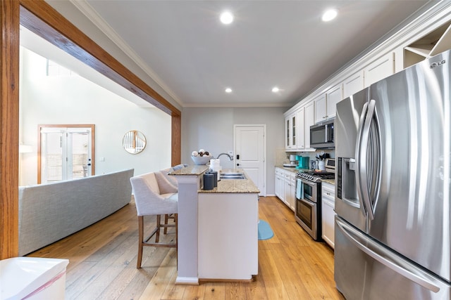 1538 Bevis St, Houston, TX 77008 - kitchen with stainless steel appliances, crown molding, white cabinets, a sink, and a breakfast bar area