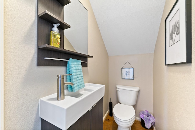 1538 Bevis St, Houston, TX 77008 - bathroom featuring toilet, vaulted ceiling, wood finished floors, vanity, and baseboards