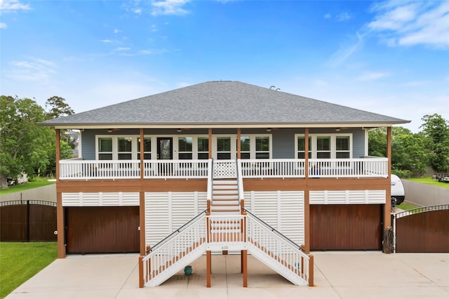 610 S Shady Ln, Shoreacres, TX 77571 - view of front of home featuring roof with shingles, covered porch, and concrete driveway