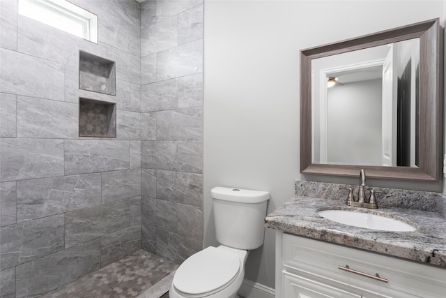 610 S Shady Ln, Shoreacres, TX 77571 - bathroom featuring vanity, toilet, a tile shower, and baseboards