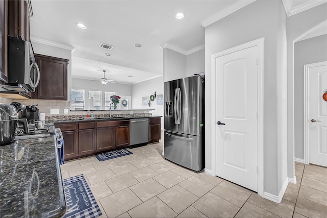 21275 Lily Springs Dr, Porter, TX 77365 - kitchen featuring appliances with stainless steel finishes, crown molding, dark brown cabinets, dark stone counters, and ceiling fan