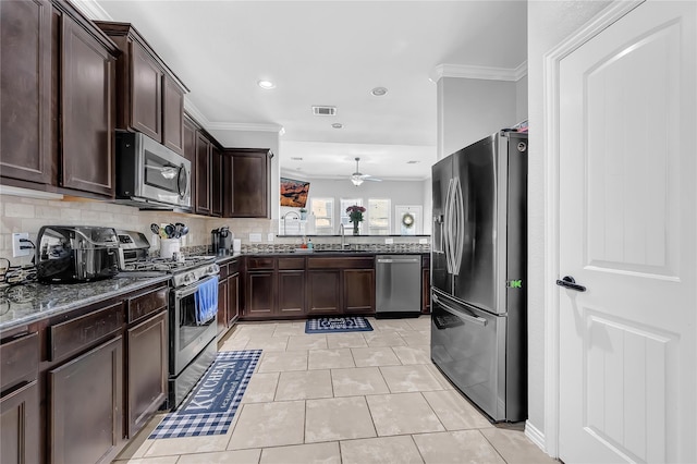 21275 Lily Springs Dr, Porter, TX 77365 - kitchen featuring stainless steel appliances, dark stone counters, ornamental molding, dark brown cabinets, and a ceiling fan