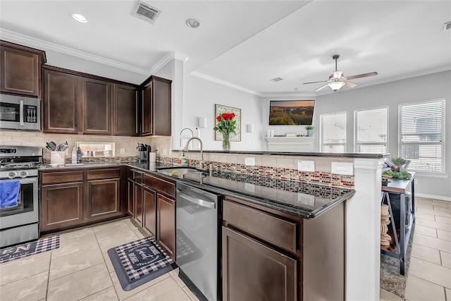 21275 Lily Springs Dr, Porter, TX 77365 - kitchen featuring stainless steel appliances, a peninsula, dark stone countertops, tasteful backsplash, and ceiling fan
