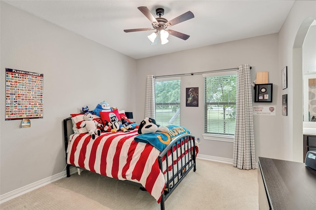27326 S Karaugh Dr, Richmond, TX 77406 - bedroom featuring arched walkways, light carpet, baseboards, and ceiling fan