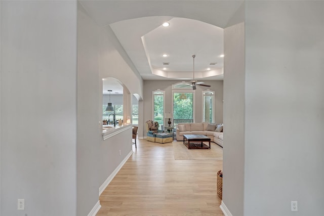 27326 S Karaugh Dr, Richmond, TX 77406 - corridor with arched walkways, baseboards, light wood-style floors, a raised ceiling, and recessed lighting