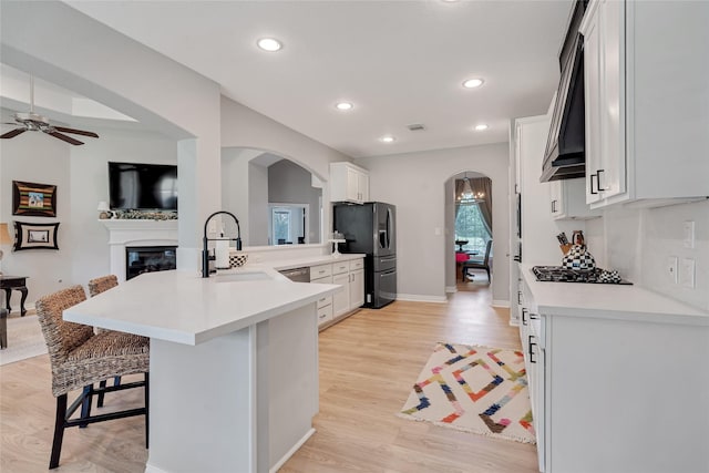 27326 S Karaugh Dr, Richmond, TX 77406 - kitchen featuring arched walkways, a sink, black fridge with ice dispenser, a ceiling fan, and a breakfast bar