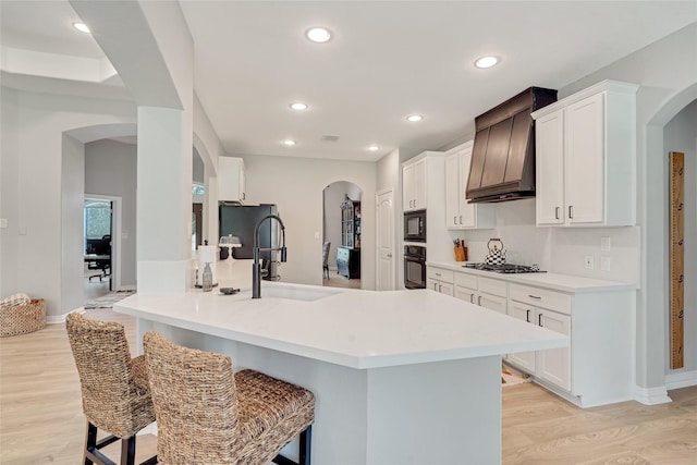 27326 S Karaugh Dr, Richmond, TX 77406 - kitchen featuring black appliances, a sink, arched walkways, custom exhaust hood, and recessed lighting