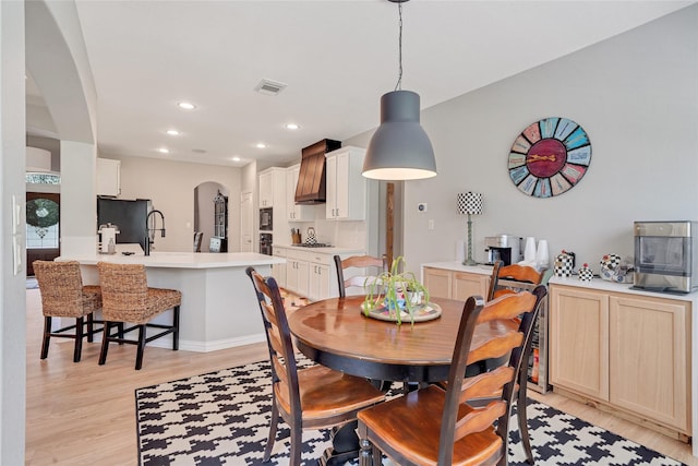 27326 S Karaugh Dr, Richmond, TX 77406 - dining room with arched walkways, light wood-style flooring, recessed lighting, and baseboards