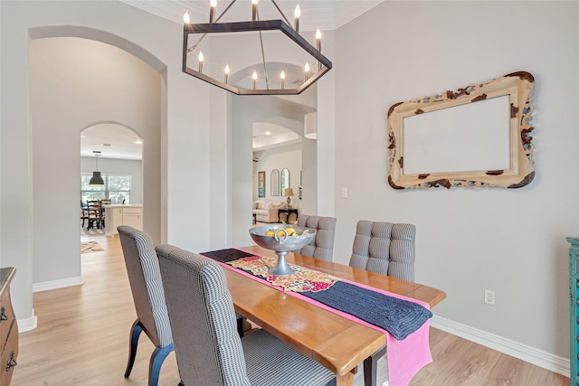27326 S Karaugh Dr, Richmond, TX 77406 - dining room with arched walkways, a chandelier, light wood-style flooring, baseboards, and ornamental molding