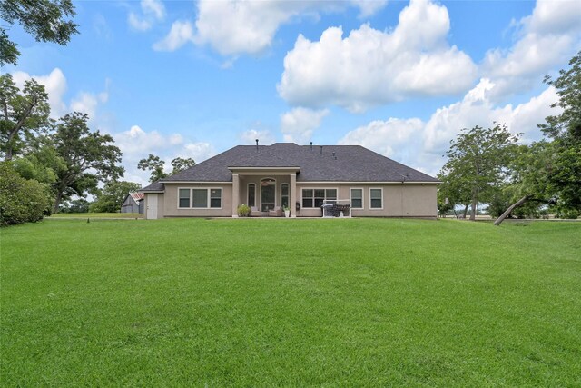 27326 S Karaugh Dr, Richmond, TX 77406 - back of property featuring stucco siding, a yard, a shingled roof, and a patio