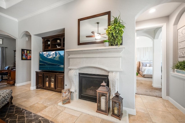 9811 Orchid Cove Ct, Cypress, TX 77433 - living room with a fireplace, a ceiling fan, ornamental molding, arched walkways, and baseboards