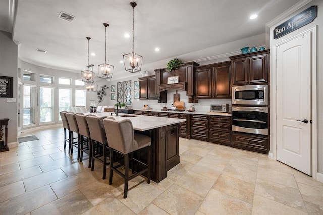 9811 Orchid Cove Ct, Cypress, TX 77433 - kitchen with appliances with stainless steel finishes, a sink, a kitchen bar, a chandelier, and recessed lighting