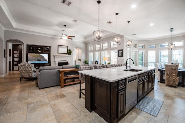 9811 Orchid Cove Ct, Cypress, TX 77433 - kitchen featuring a sink, stainless steel dishwasher, arched walkways, a ceiling fan, and a kitchen breakfast bar