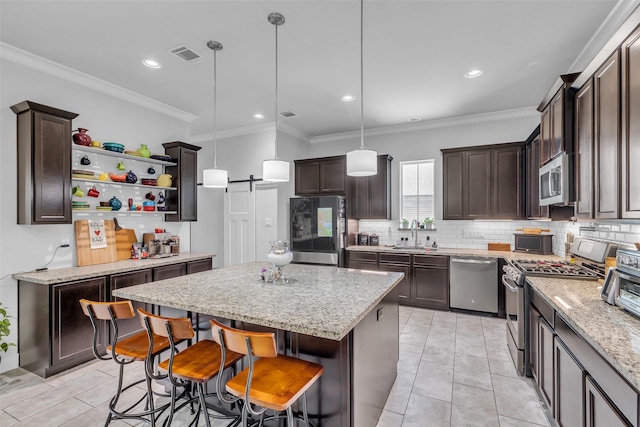 3009A Bell St, Houston, TX 77003 - kitchen featuring stainless steel appliances, dark brown cabinetry, decorative backsplash, a kitchen island, and crown molding