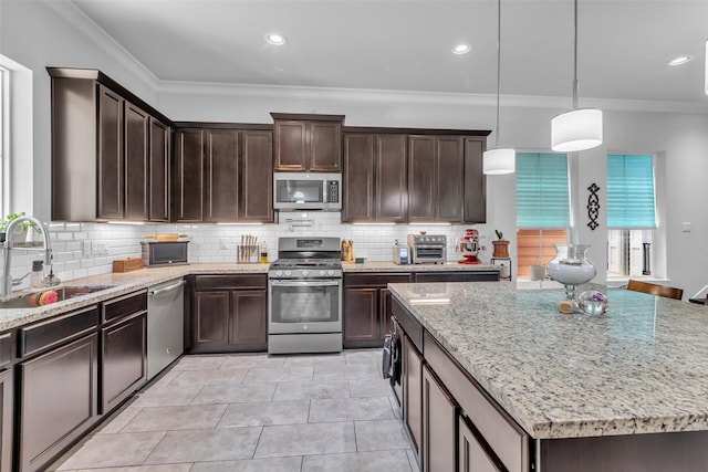 3009A Bell St, Houston, TX 77003 - kitchen with stainless steel appliances, a sink, ornamental molding, light stone countertops, and dark brown cabinets