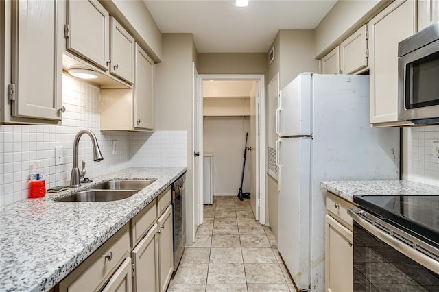 8787 Brae Acres Rd Unit 403, Houston, TX 77074 - kitchen featuring a sink, appliances with stainless steel finishes, decorative backsplash, and baseboards