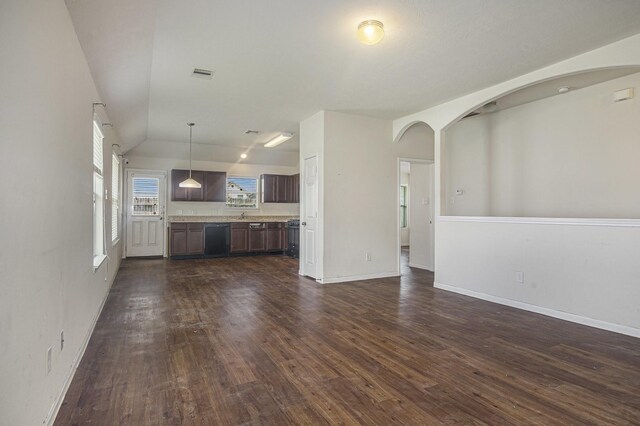 21606 Micheala Way, Humble, TX 77338 - unfurnished living room with dark wood finished floors, lofted ceiling, baseboards, and arched walkways