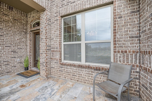 9407 Mineral Rock Ln, Richmond, TX 77407 - view of exterior entry featuring brick siding and a patio area