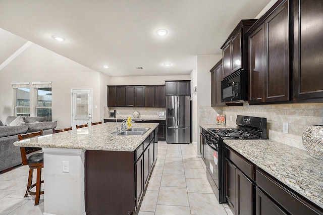 9407 Mineral Rock Ln, Richmond, TX 77407 - kitchen with black appliances, a sink, open floor plan, tasteful backsplash, and a kitchen breakfast bar