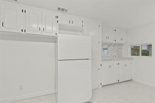 807 Aron St, Baytown, TX 77520 - kitchen featuring freestanding refrigerator, light marble finish floors, white cabinetry, baseboards, and light countertops
