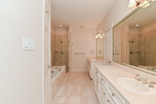 5422 Gibson St Unit A, Houston, TX 77007 - bathroom with a stall shower, two vanities, a bath, tile patterned floors, and baseboards