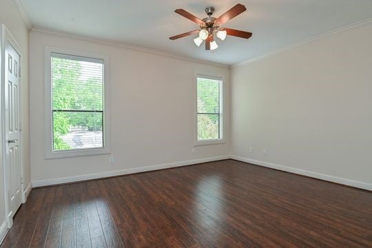 5422 Gibson St Unit A, Houston, TX 77007 - empty room featuring dark wood-style floors, healthy amount of natural light, ornamental molding, a ceiling fan, and baseboards