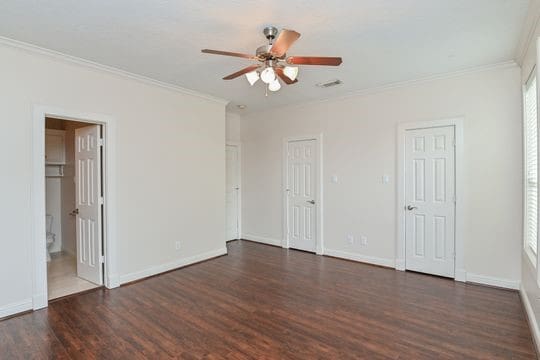 5422 Gibson St Unit A, Houston, TX 77007 - unfurnished bedroom with ornamental molding, wood finished floors, multiple closets, baseboards, and a ceiling fan