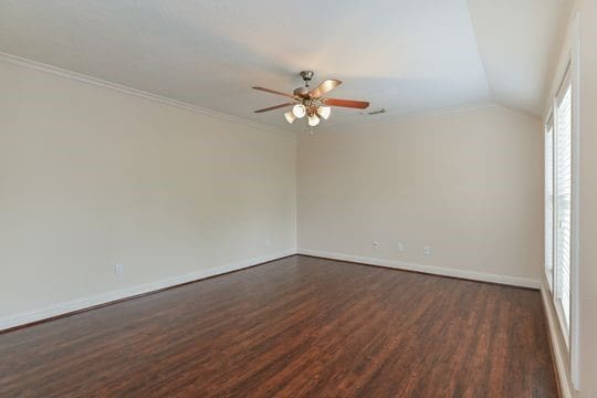 5422 Gibson St Unit A, Houston, TX 77007 - empty room with dark wood-type flooring, baseboards, ceiling fan, crown molding, and lofted ceiling