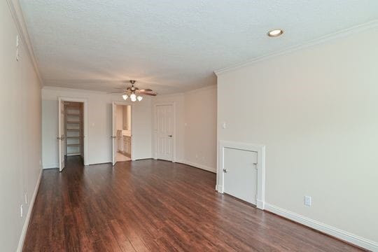 5422 Gibson St Unit A, Houston, TX 77007 - empty room with ornamental molding, dark wood-type flooring, a ceiling fan, and baseboards