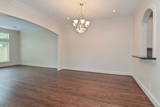5422 Gibson St Unit A, Houston, TX 77007 - spare room featuring a chandelier, dark wood finished floors, ornamental molding, arched walkways, and baseboards