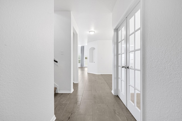 14806 Meadow Acre Trl, Houston, TX 77049 - corridor with arched walkways, a textured wall, healthy amount of natural light, baseboards, and stairs