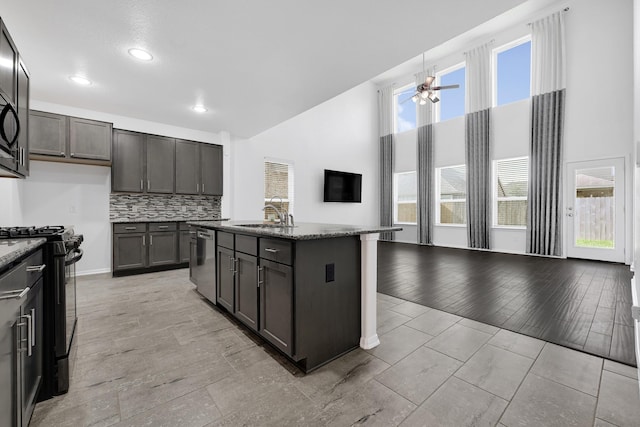14806 Meadow Acre Trl, Houston, TX 77049 - kitchen featuring black range with gas stovetop, dishwasher, a sink, dark stone countertops, and a high ceiling