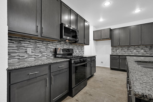 14806 Meadow Acre Trl, Houston, TX 77049 - kitchen with range with gas cooktop, stainless steel microwave, recessed lighting, light stone countertops, and decorative backsplash